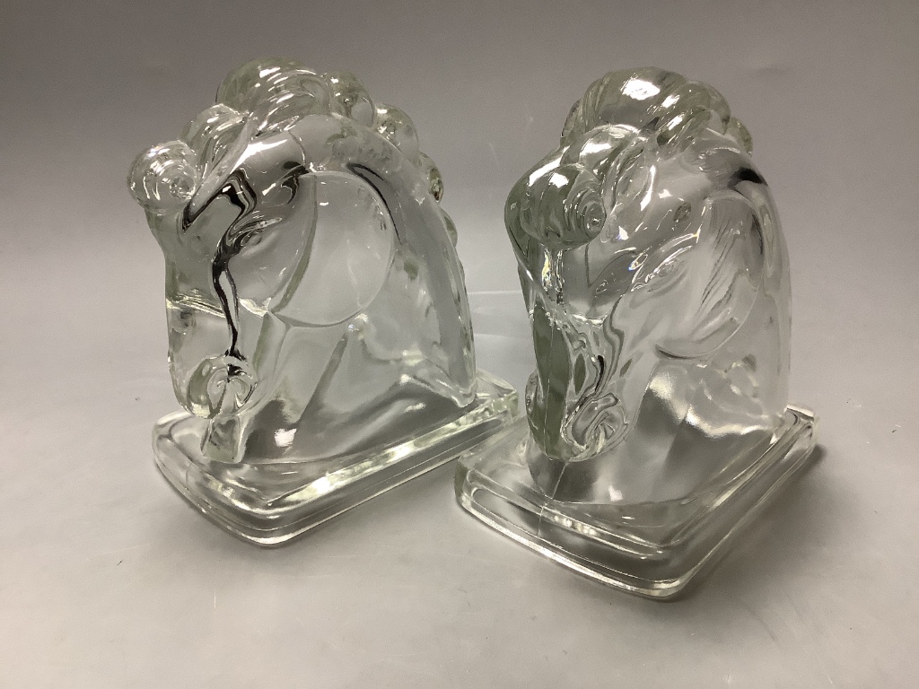 A pair of American press moulded glass horse head bookends, height 14cm